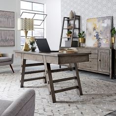 a white desk sitting in the middle of a living room next to a gray couch