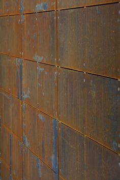 an orange brick wall with rusted paint on it