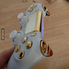 a close up of a person holding a nintendo wii game controller in their left hand