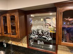 a kitchen with wooden cabinets and black granite counter tops, along with an etched glass window