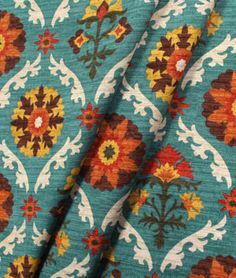 a blue and orange floral print fabric with an intricate design on the bottom half of it