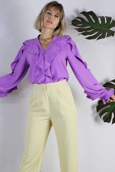 Add some flair to your look with Anita. Featuring ruffles on the bodice of the shirt and the sleeves, she sure makes a statement.Finish the LookPerfect for work or a date night with slacks or a skirtDress it down with denim shorts or your favorite summer skirt.Style FeaturesRuffled detailsButton DownCuffed Wrists Size + FitModel is 5`9" And Wearing Size Small Fits True to Size Fabric100% Polyester