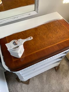 a wooden table with a mirror on top of it and a brush in the middle