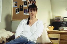 a woman sitting on top of a bed in a bedroom