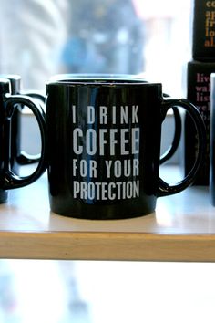 two black coffee mugs sitting on top of a table