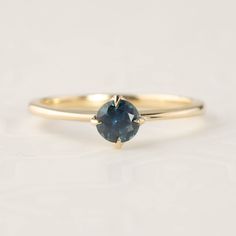 a gold ring with a blue sapphire stone in the center, on a white background