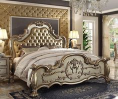 a fancy bedroom with gold furniture and chandelier