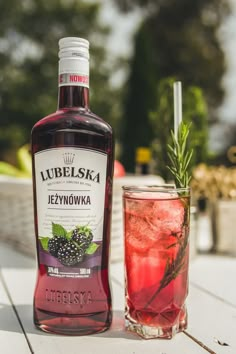 a bottle of liquor sitting next to a glass filled with liquid and garnish