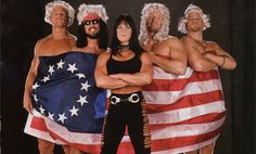 the group of men are dressed up in costumes and standing next to an american flag