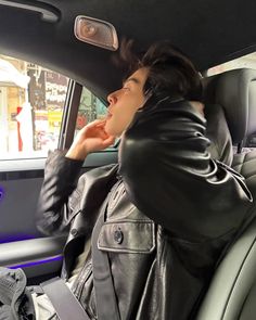 a woman sitting in the back seat of a car