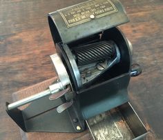 an old fashioned machine on top of a wooden table