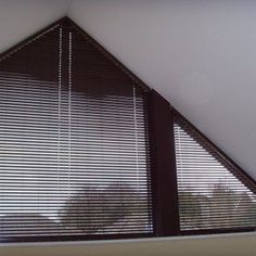 the corner of a room with a window covered in blinds