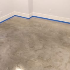 an empty room with white walls and blue tape on the floor is shown in this image