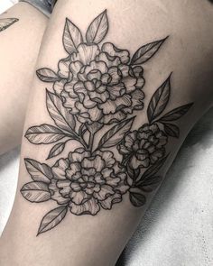 a black and white flower tattoo on the thigh