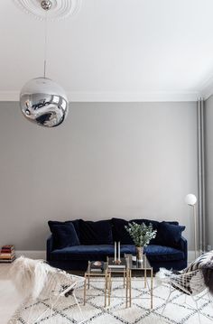 a living room filled with furniture and a large mirror ball hanging above the couches