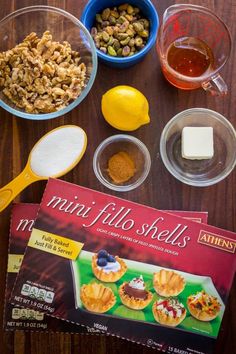 ingredients to make mini filo shells are displayed on a wooden table with a recipe book