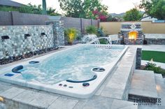 an outdoor hot tub in the middle of a backyard