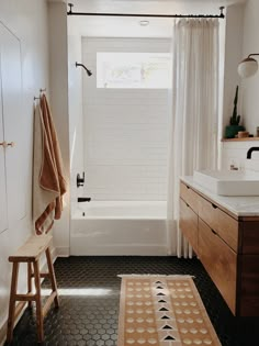 a bathroom with black and white floor tiles