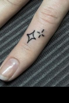 a person's hand with a small star tattoo on their left thumb and finger