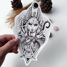 a hand holding up a sticker with an image of a horned goat on it