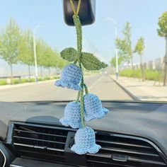 a car dashboard with a crocheted flower hanging from the dash board