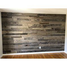 an empty room with wood paneling on the wall and hard wood floors in it