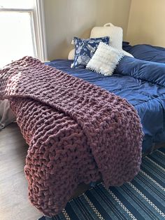 a bed with a blue blanket and pillows on it