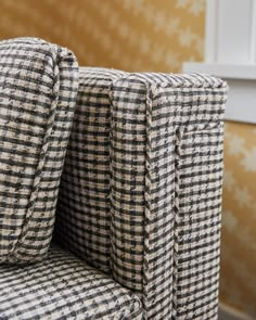 an upholstered chair with black and white checkered fabric