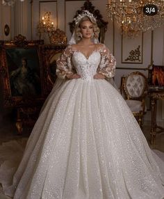 a woman in a wedding dress standing next to a chandelier