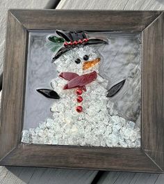 a snowman made out of glass in a frame