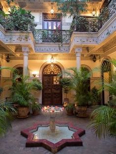 an indoor courtyard with potted plants and lights