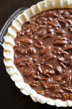 a pie crust filled with pecans on top of a table