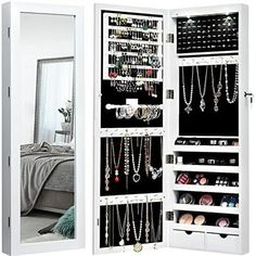 an open mirrored closet with jewelry hanging on the door and mirror in front of it