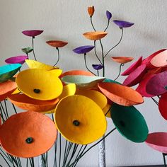 a vase filled with paper flowers on top of a table