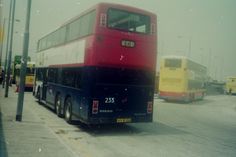 a double decker bus is parked on the side of the road in front of other buses