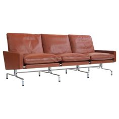 a brown leather couch sitting on top of metal legs