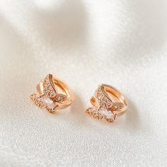 These delicate earrings feature one touch small hoops, made of high-quality rose gold. The charming cubic zirconia butterfly adds a touch of elegance, while the nickel-free post ensures comfort and safety. Perfect for any occasion.  Material: Cubic zirconia, Nickel-free post Size: 1.1cm (Length) The earring posts are in silver which are good for sensitive ears. It is also a perfect gift idea for special events, occassions and celebrations like birthday/anniversary/Valentine's Day/Christmas. Opti Delicate Rose Gold Huggie Earrings, Rose Gold Cubic Zirconia Huggie Earrings, Rose Gold Cubic Zirconia Small Hoop Huggie Earrings, Rose Gold Cubic Zirconia Huggie Earrings, Tarnish Resistant, Delicate Rose Gold Tarnish Resistant Huggie Earrings, Delicate Rose Gold Tarnish-resistant Huggie Earrings, Dainty Rose Gold Hoop Earrings With Cubic Zirconia, Rose Gold Cubic Zirconia Cartilage Earrings As Gift, Dainty Rose Gold Cubic Zirconia Huggie Earrings