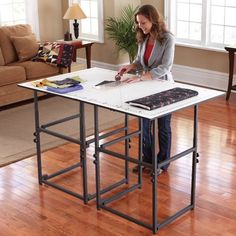 a woman standing at a table with a laptop on it