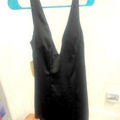 a woman's black dress hanging on a shower curtain