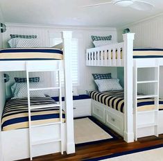 two bunk beds with blue and white bedding in a room