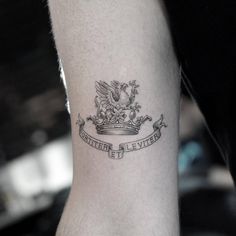 a man with a tattoo on his arm has a crown and an eagle in the middle