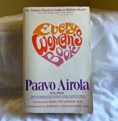 the book every woman's guide to health by paavo ariola on a bed