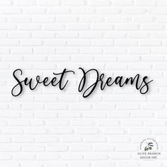 the word sweet dreams on a white brick wall with black lettering in cursive font