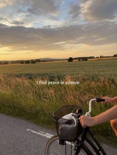 a person riding a bike down a road with the words i find peace in silence