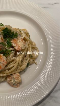 a white plate topped with pasta and shrimp