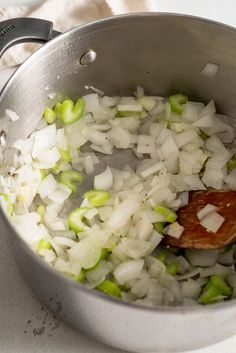 onions and celery are being cooked in a pot