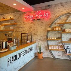 the interior of a coffee shop with brick walls and neon signs on the front wall