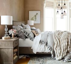 a bedroom with a bed, nightstands and chandelier hanging from the ceiling