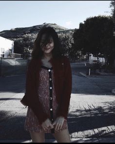 a woman standing in the street with her legs crossed