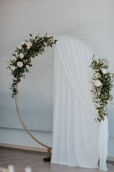 a wedding arch decorated with white flowers and greenery